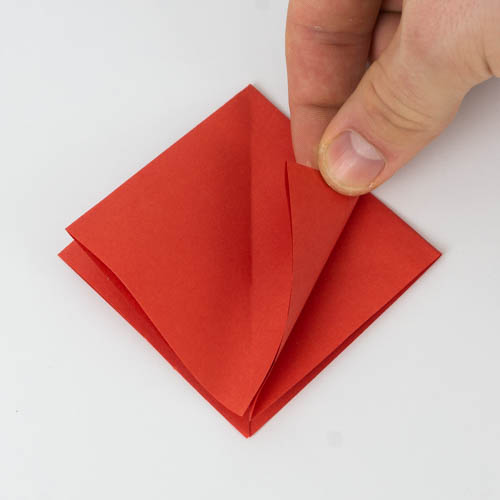 Falte die beiden unteren Seiten der Origamifigur zur mittleren Falz.