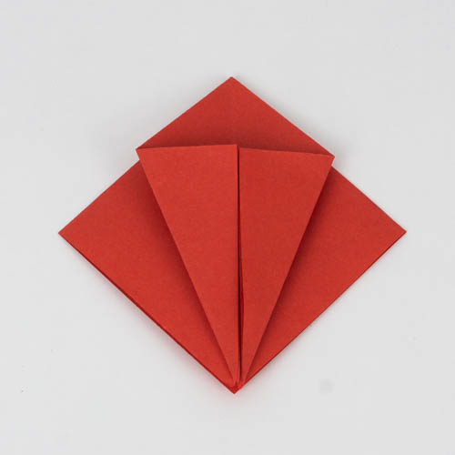 Origami Kranich falten. Falte die unteren Seite hin zur Mitte.